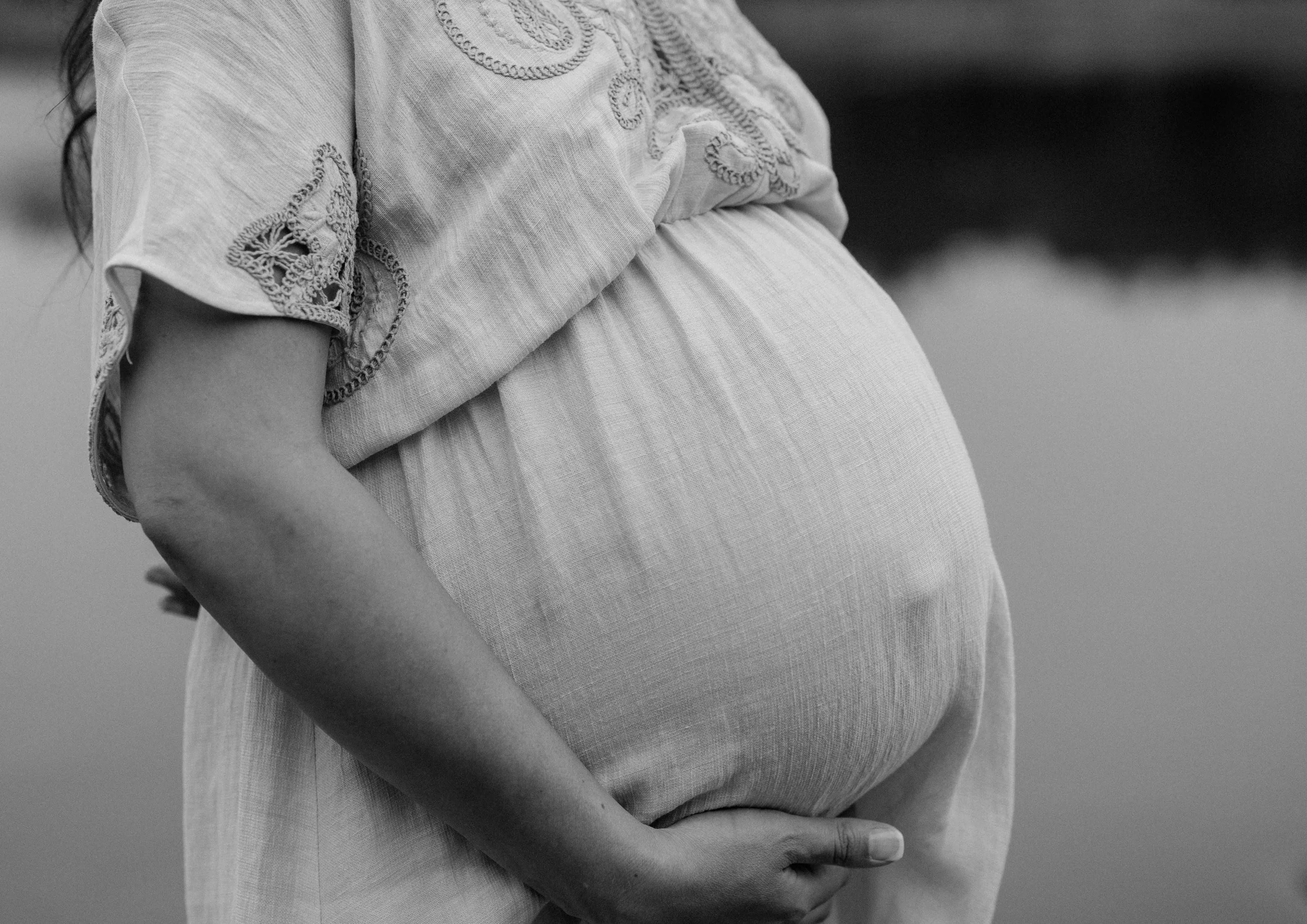 Zwangere vrouw met haar handen om haar buik